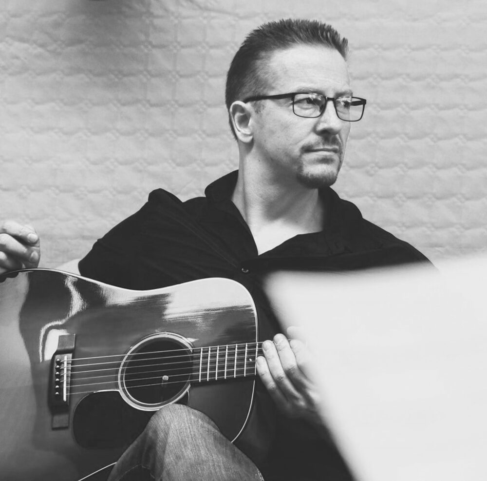Alexander Stakenburg with a steel string acoustic guitar